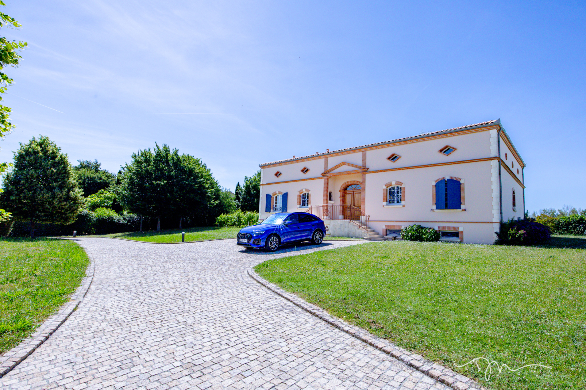 Villa de 335m2 avec piscine et jardin à Préserville, vue extérieure et allée pavée.