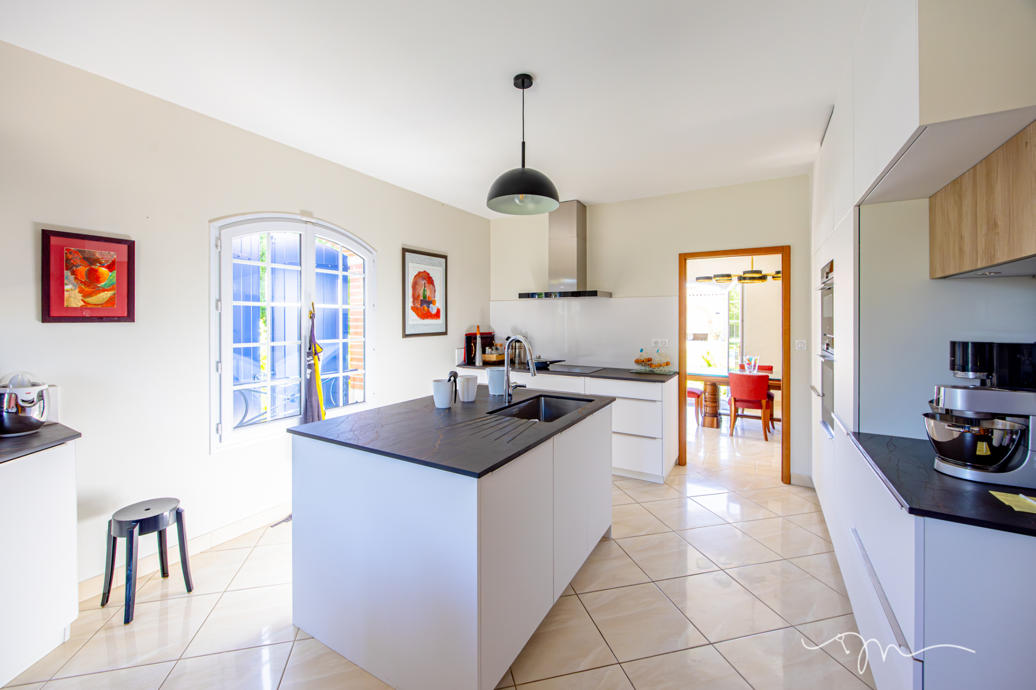 Cuisine moderne avec îlot central et vue sur salle à manger, villa à Préserville.