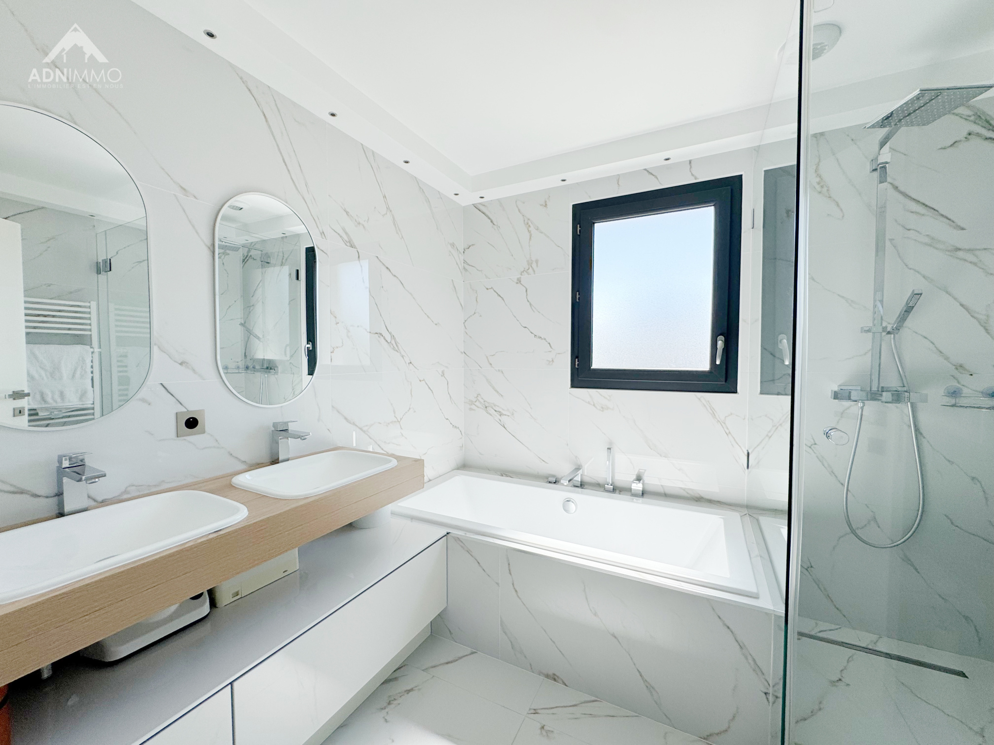 Salle de bain contemporaine Salle de bain moderne avec baignoire et douche, murs en marbre, lumière naturelle