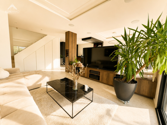 Intérieur d'une maison contemporaine avec salon lumineux, canapé et télévision.