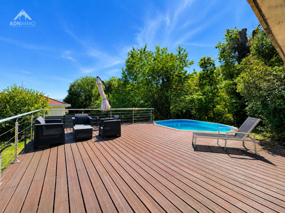 Terrasse en bois avec piscine et chaises longues, entourée de verdure à Crozet.