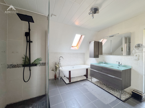 Salle de bain moderne avec douche à l'italienne et baignoire, fenêtres de toit.