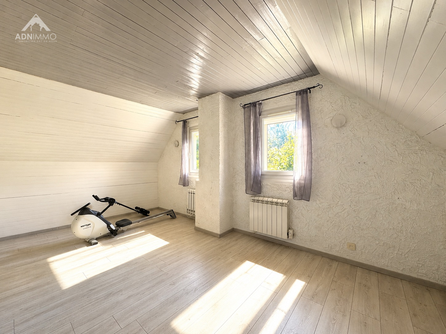 Intérieur d'une maison avec un espace lumineux et un vélo d'appartement.