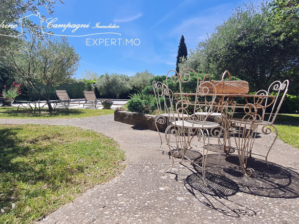 Terrace with wrought iron furniture and wooded garden in Mazan.