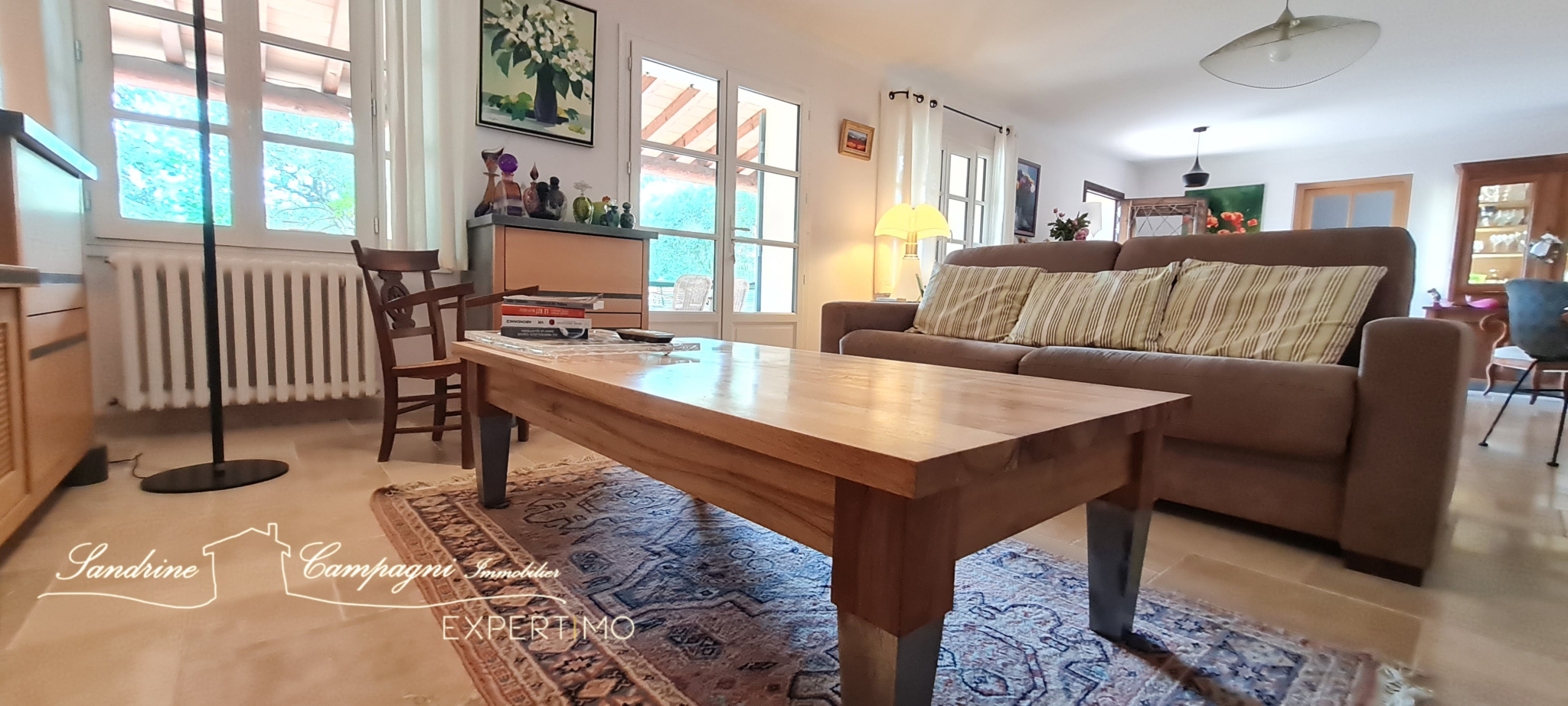 Interior of a renovated house with a comfortable living room and a wooden table.