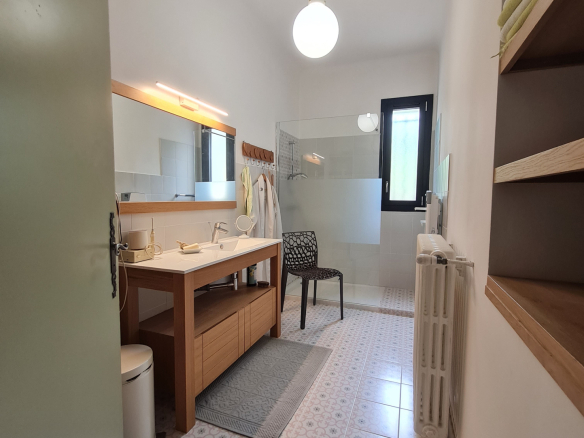 Modern bathroom with sink, shower and decorative tiles.