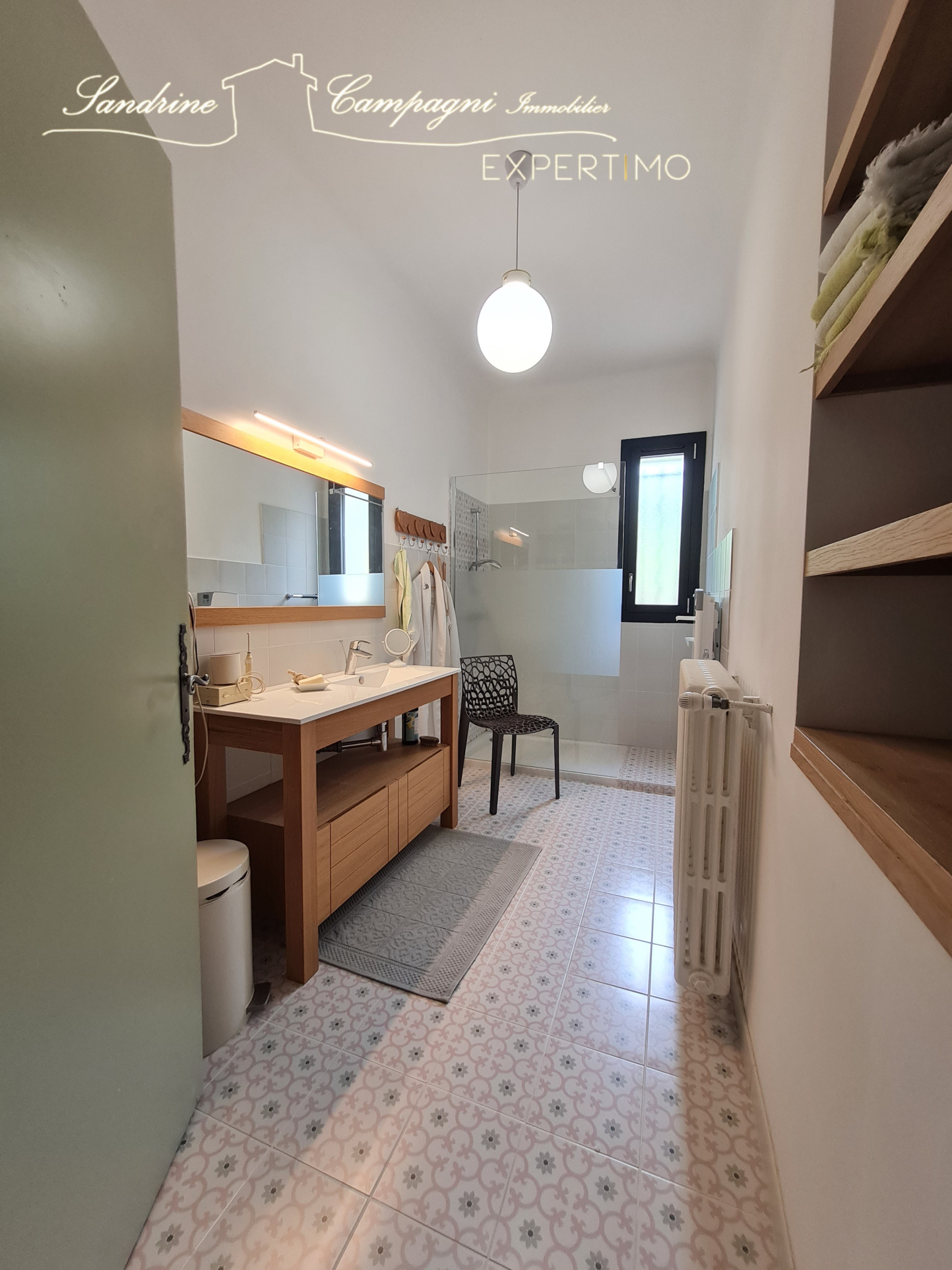 Modern bathroom with sink, shower and decorative tiles.