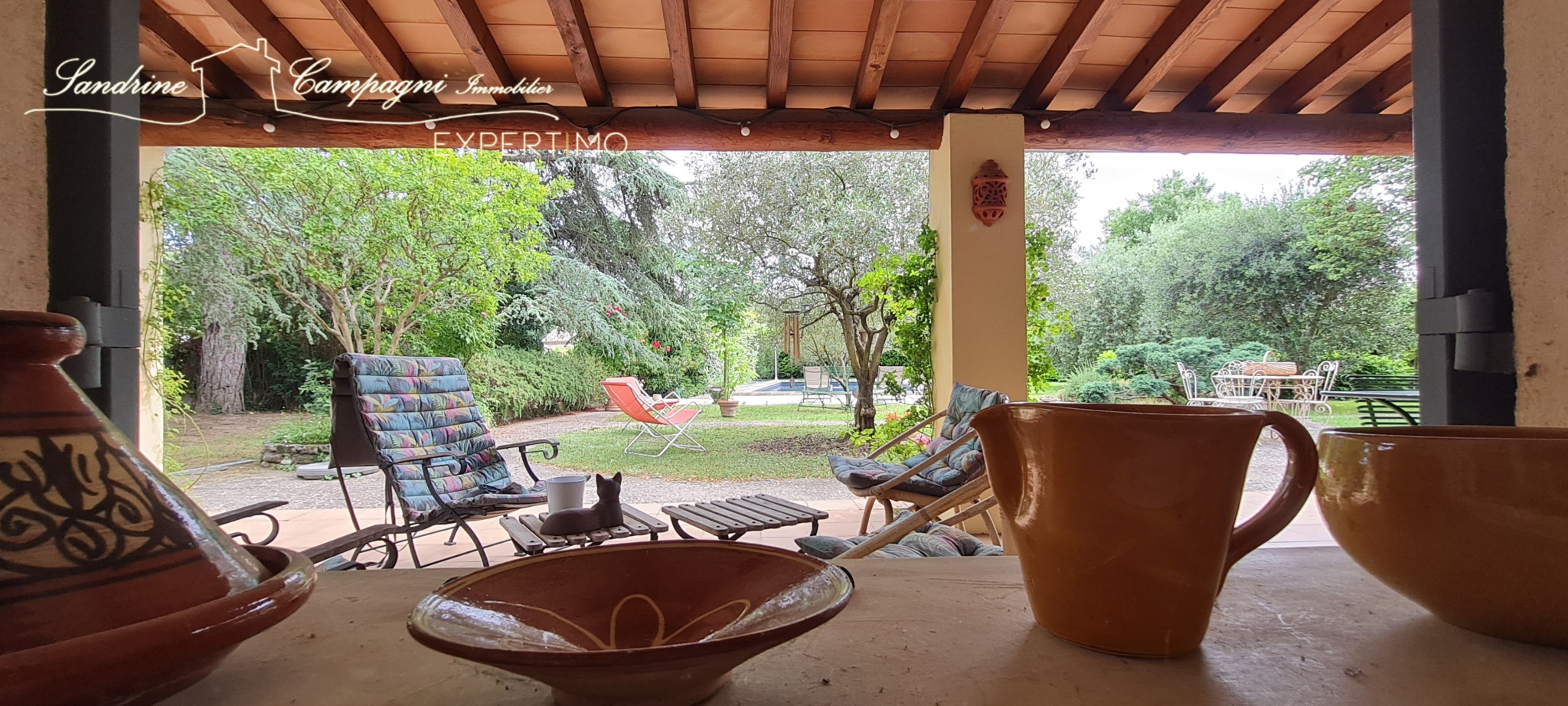 View from a house with garden, swimming pool and garden furniture in Mazan.