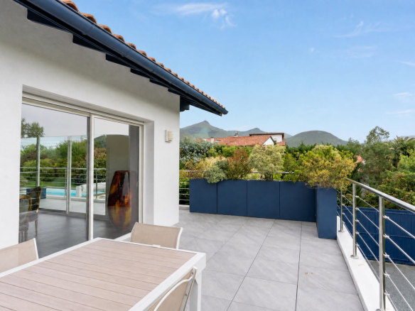 Terrasse d'une propriété familiale avec vue sur la montagne et piscine.