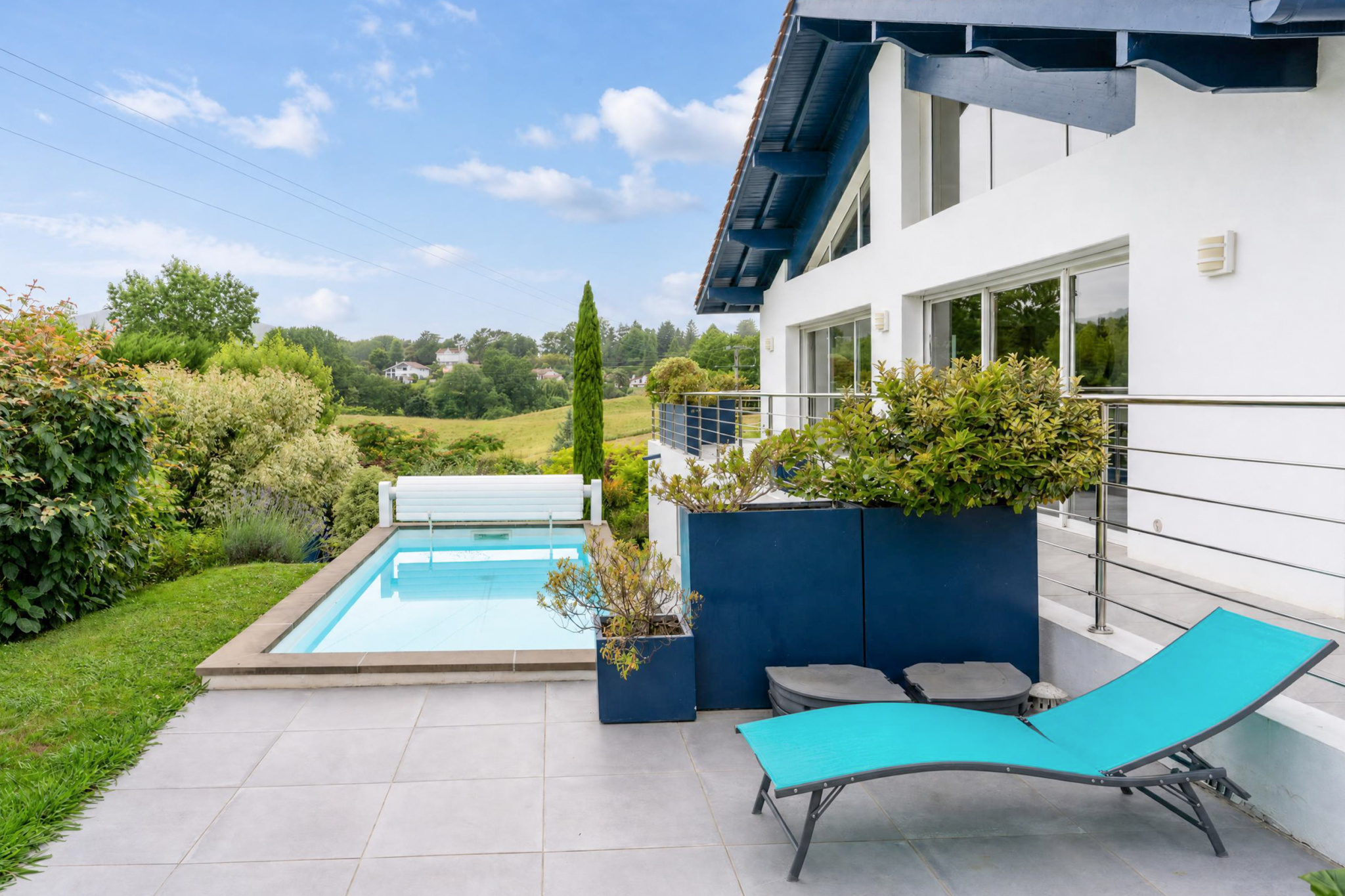 Propriété familiale avec piscine à Urrugne Vue de la piscine et de la terrasse d'une propriété familiale à Urrugne, avec jardin paysagé.