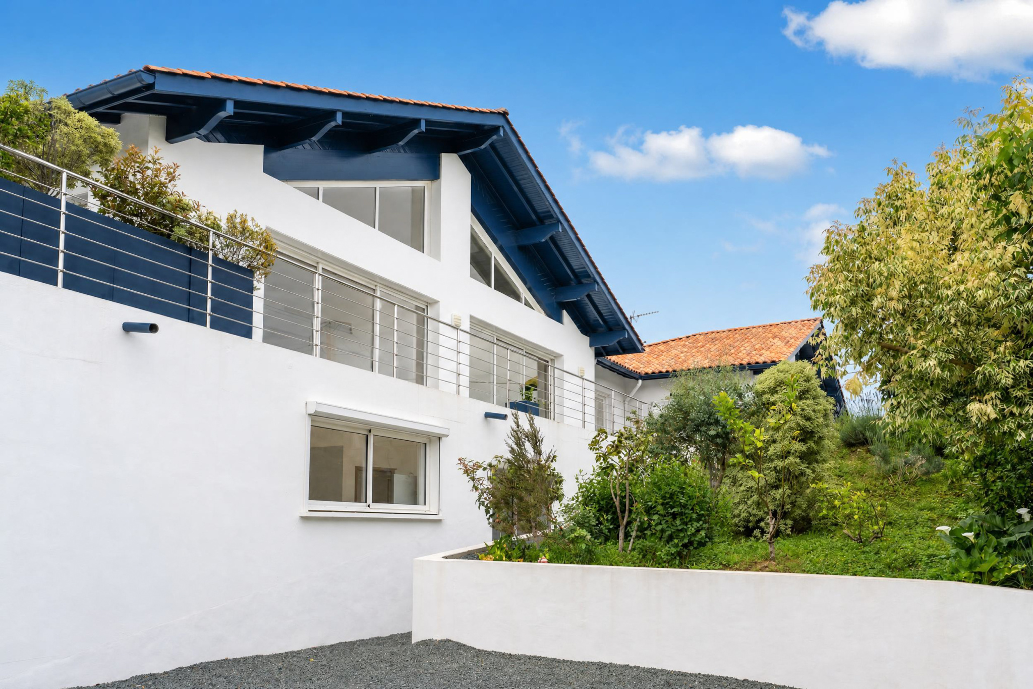 Propriété familiale à Urrugne Vue extérieure d'une propriété familiale à Urrugne avec jardin et piscine.