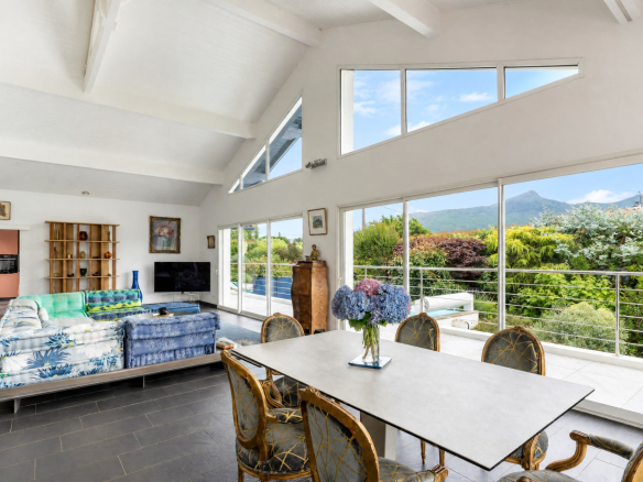Intérieur d'une propriété familiale avec vue sur la Rhune, salon lumineux et espace repas.