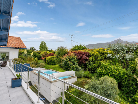 Vue de la propriété familiale avec piscine et jardin, à Urrugne, avec la montagne Rhune en arrière-plan.