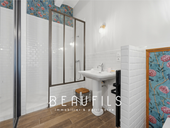 Salle de bain moderne avec douche, lavabo et décor floral à Vergèze.