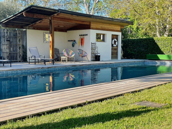 Piscine chauffée de 15 x 5 m avec espace détente et jardin verdoyant dans un mas rénové.