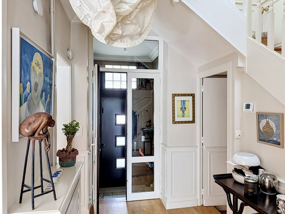 Entrée d'une maison de caractère avec décoration artistique et mobilier moderne.