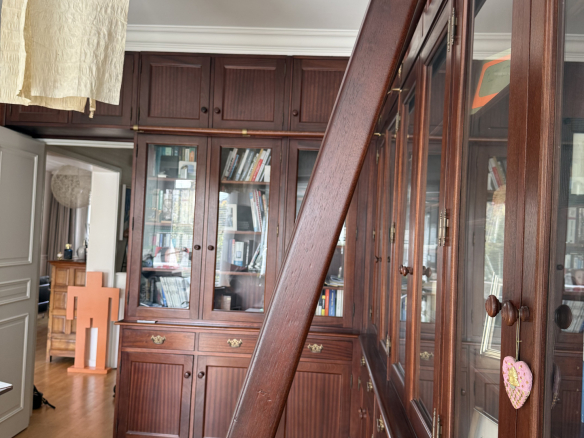 Intérieur d'une maison avec des meubles en bois et des étagères vitrées.