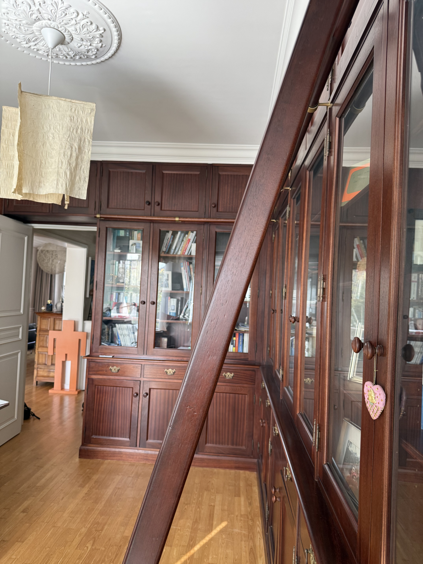 Intérieur d'une maison avec des meubles en bois et des étagères vitrées.