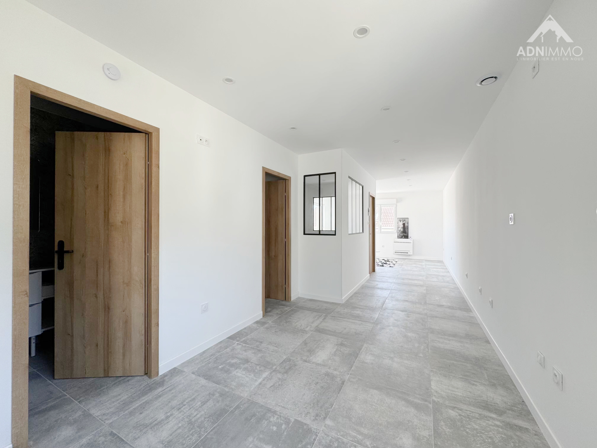 Intérieur d’une maison à Farges Intérieur d'une maison moderne à Farges, avec couloir lumineux et portes en bois.