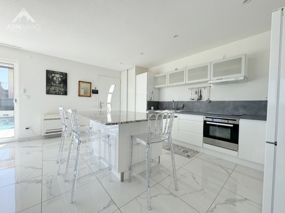 Cuisine moderne et lumineuse avec îlot central dans une maison à Farges.