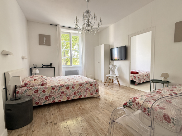 Chambre d'une demeure du XVIIIe siècle avec deux lits et une décoration soignée.