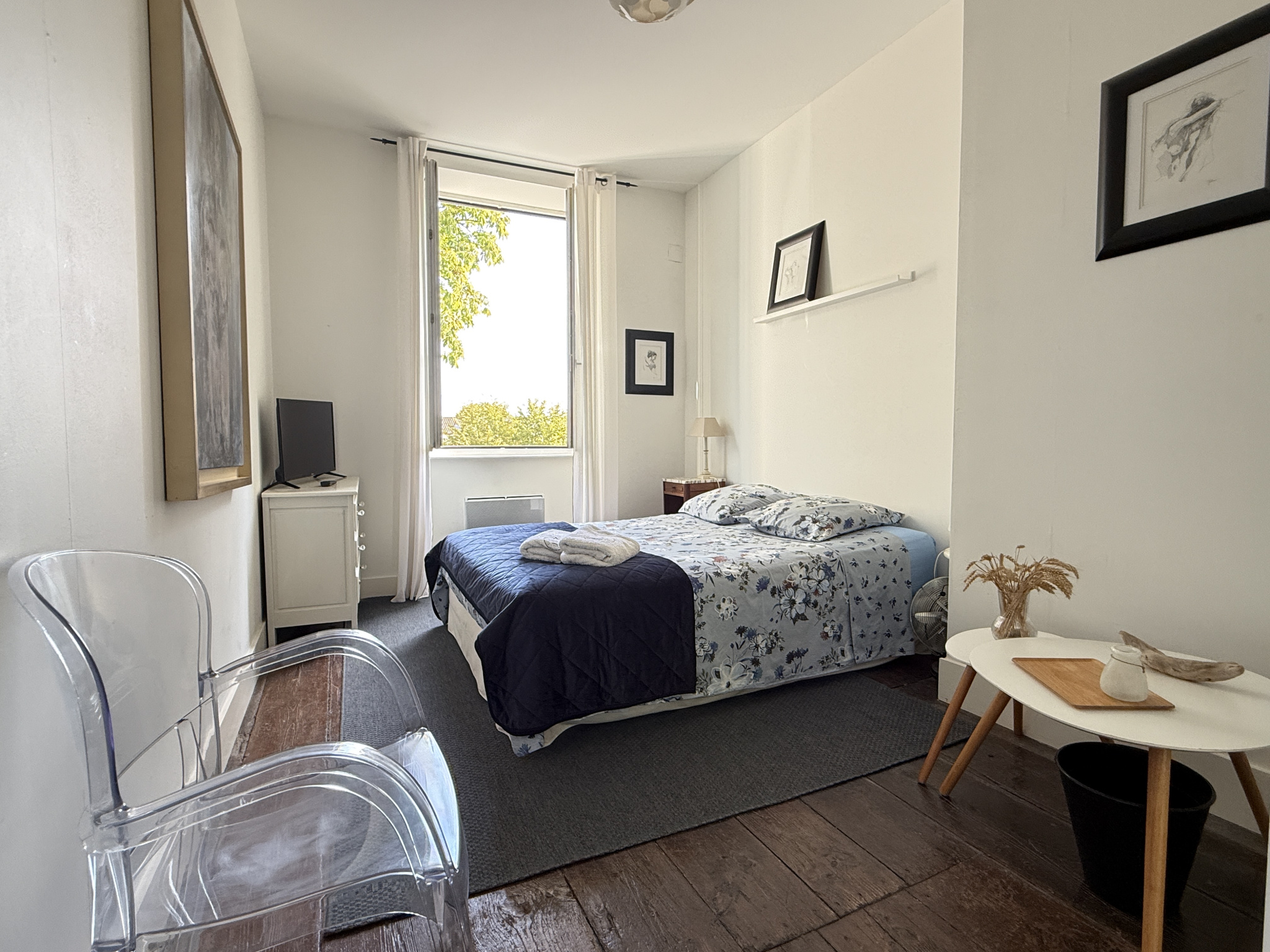 Chambre d'une maison de caractère avec lit, bureau et fenêtre lumineuse à Saint-Jean-de-Liversay.