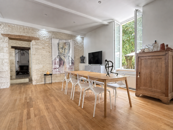 Intérieur d'une maison de caractère du XVIIIe siècle avec une salle à manger lumineuse et des murs en pierre.