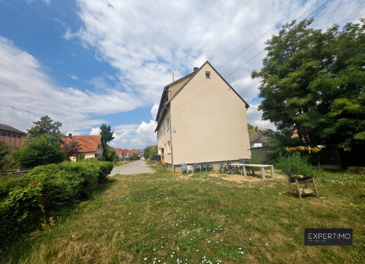 Immeuble de rapport à Ensisheim Immeuble de rapport à vendre à Ensisheim, vue extérieure avec jardin et stationnement.
