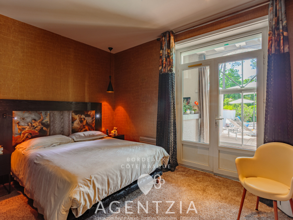Chambre d'un appartement de prestige à Bidart, avec lit double et accès à un jardin.