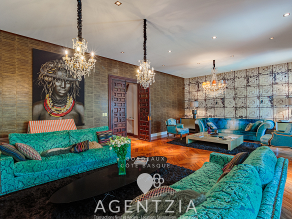 Intérieur d'un appartement de prestige à Bidart avec un salon élégant, des canapés turquoise et des lustres.