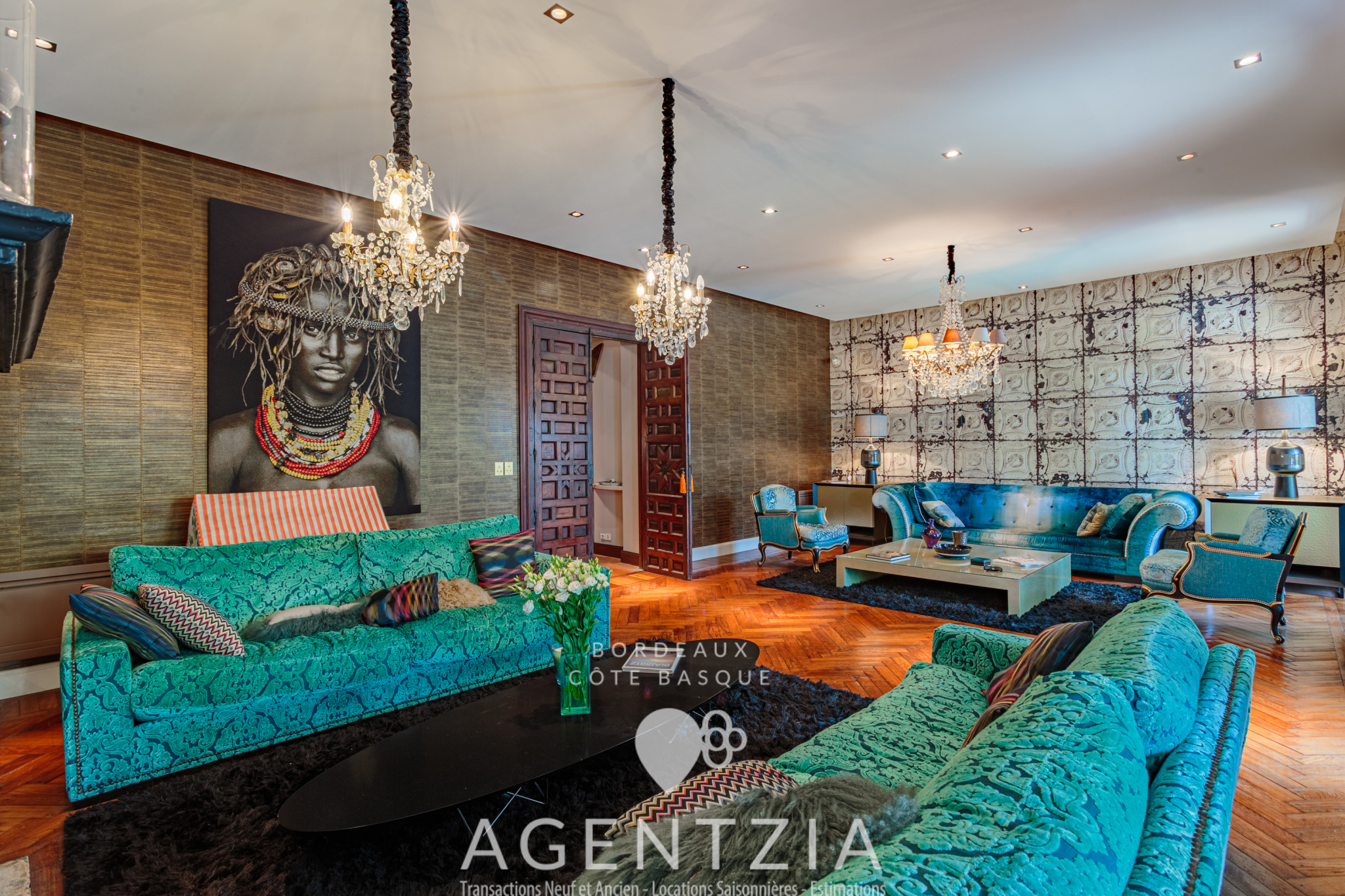 Salon d’un appartement de luxe à Bidart Intérieur d'un appartement de prestige à Bidart avec un salon élégant, des canapés turquoise et des lustres.