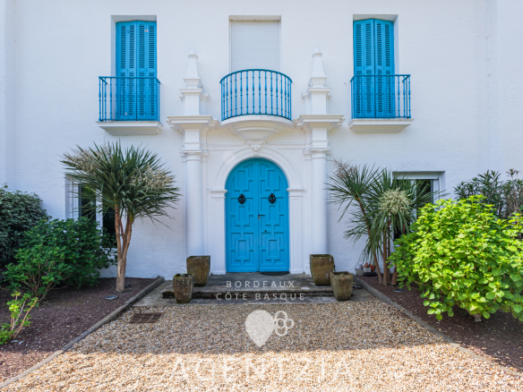 Entrée de la Villa Pardo à Bidart avec portes bleues et jardin paysager.