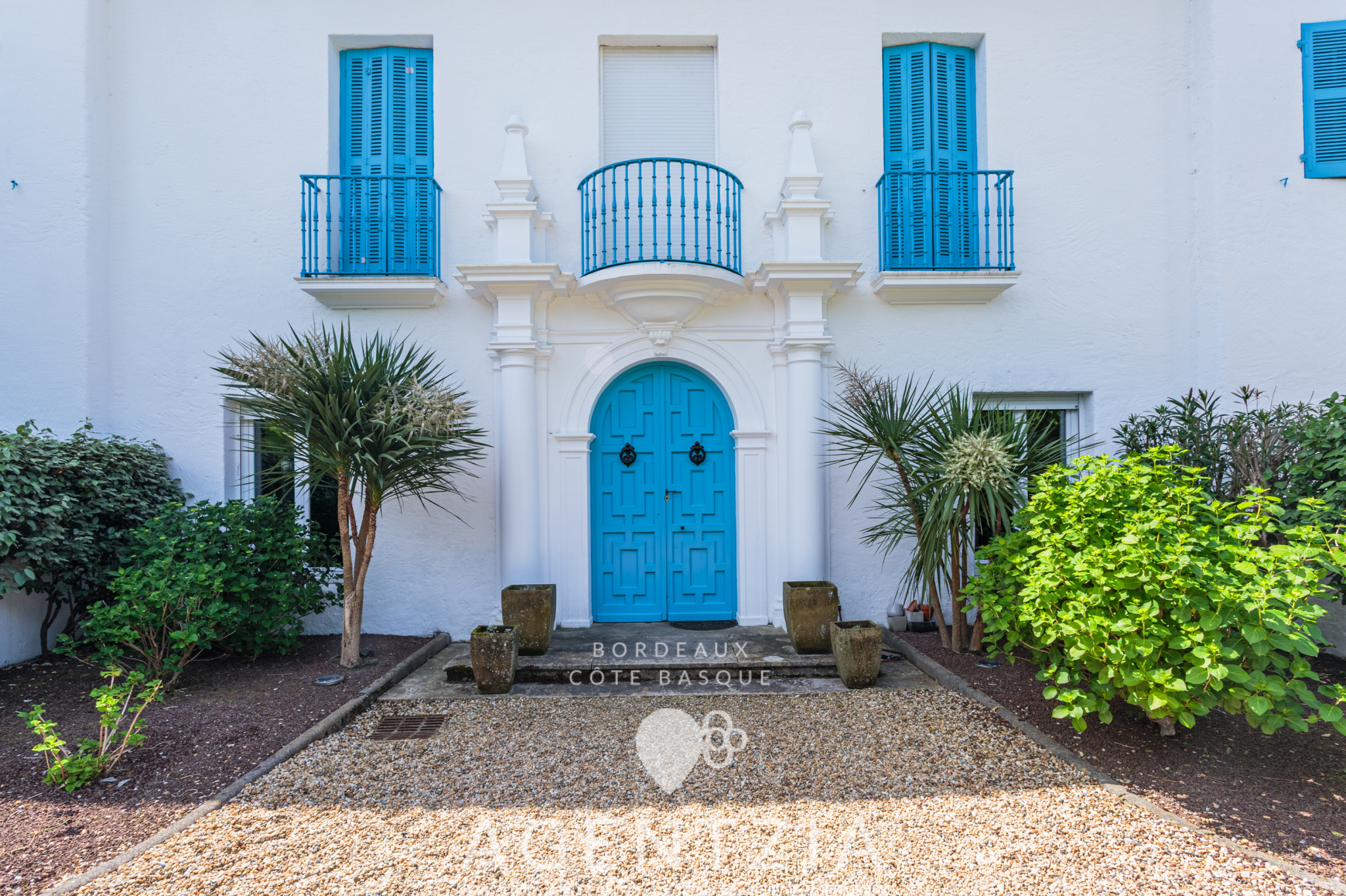 Entrée de la Villa Pardo à Bidart Entrée de la Villa Pardo à Bidart avec portes bleues et jardin paysager.