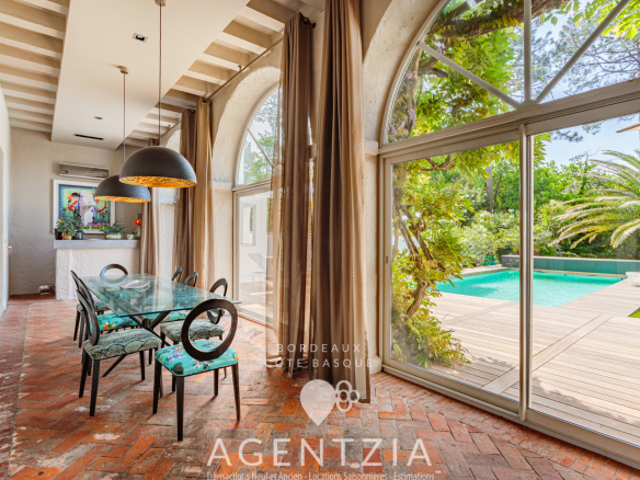 Intérieur d'un appartement de prestige à Bidart avec salle à manger et vue sur la piscine.