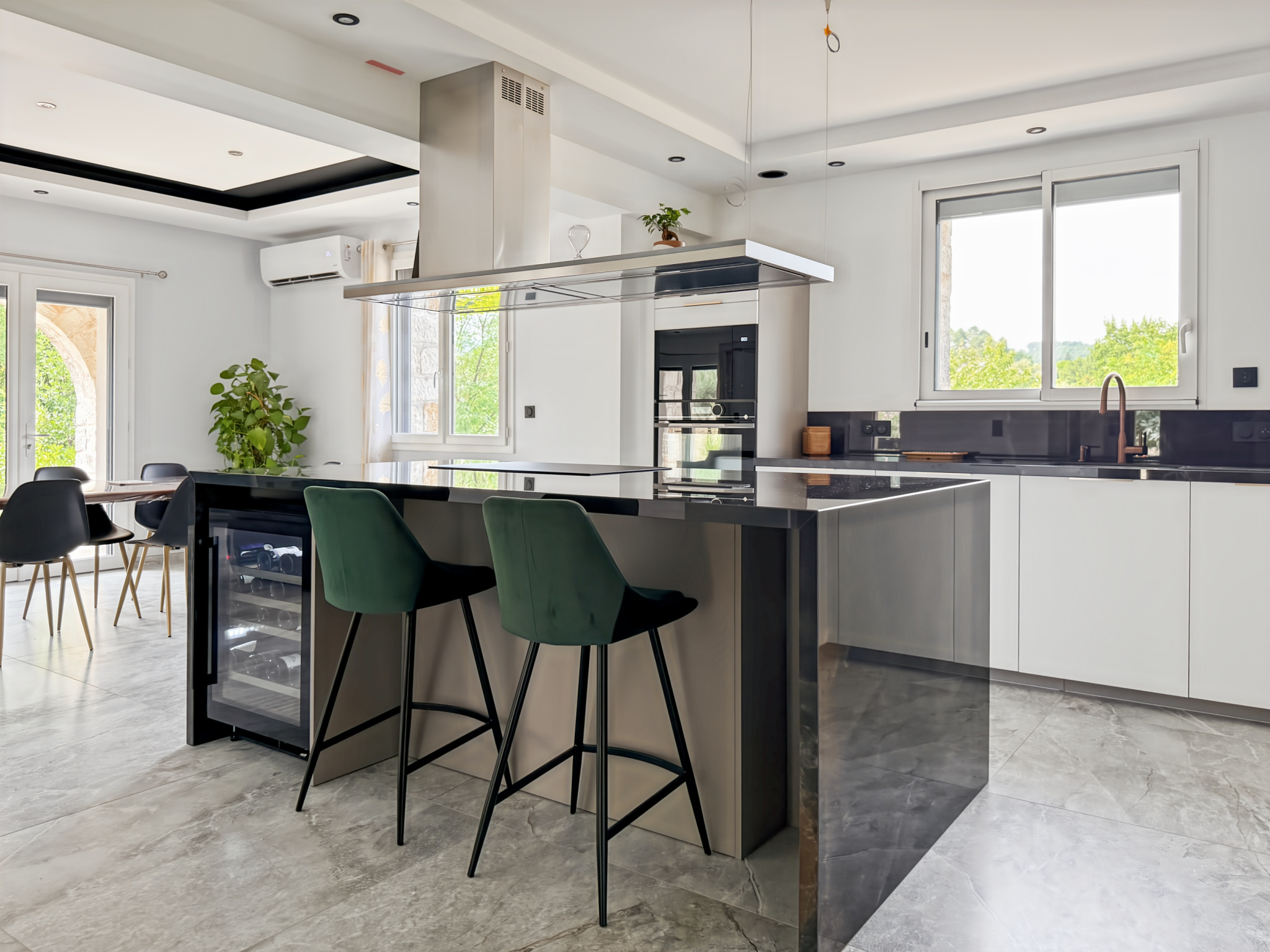 Cuisine moderne avec bar et chaises hautes dans une maison rénovée à Joyeuse.