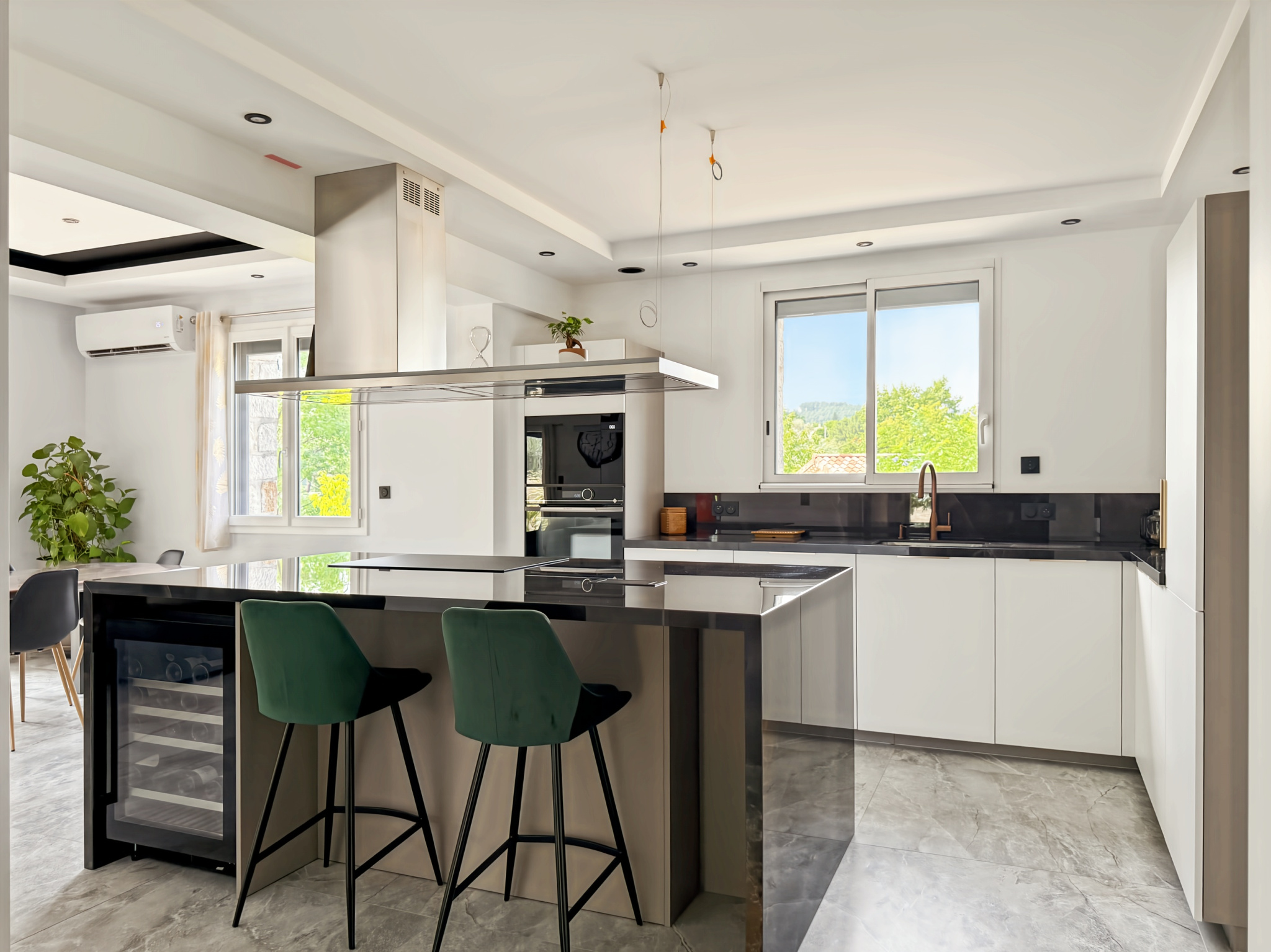 Cuisine moderne et spacieuse avec îlot central et équipements récents dans une maison rénovée.