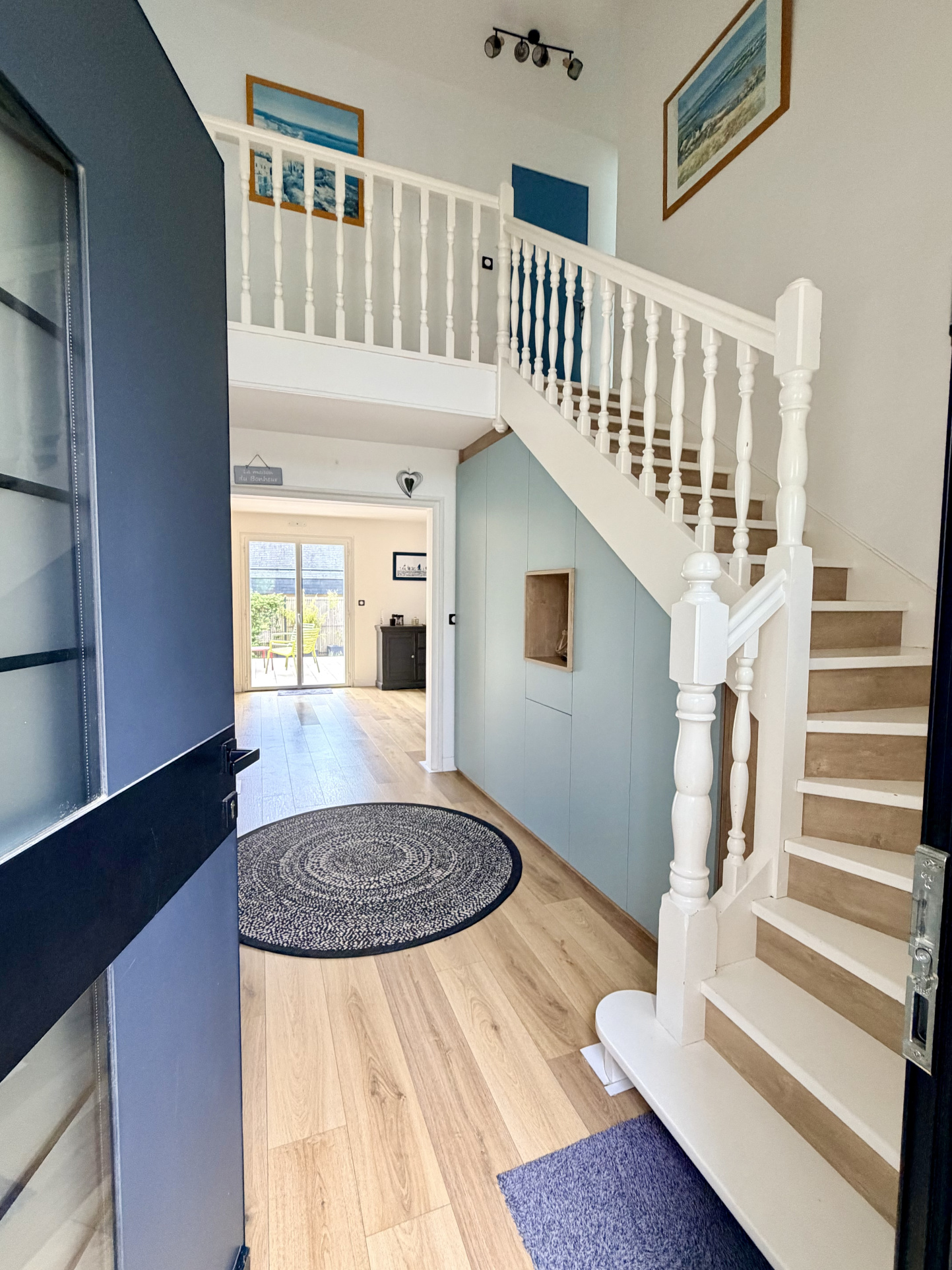 Intérieur d'une maison contemporaine avec un hall d'entrée lumineux et un escalier en bois.