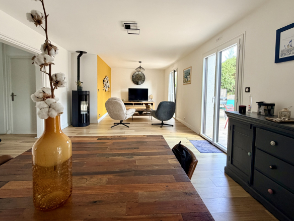 Intérieur d'une maison contemporaine à Vannes avec un salon lumineux et une table en bois.