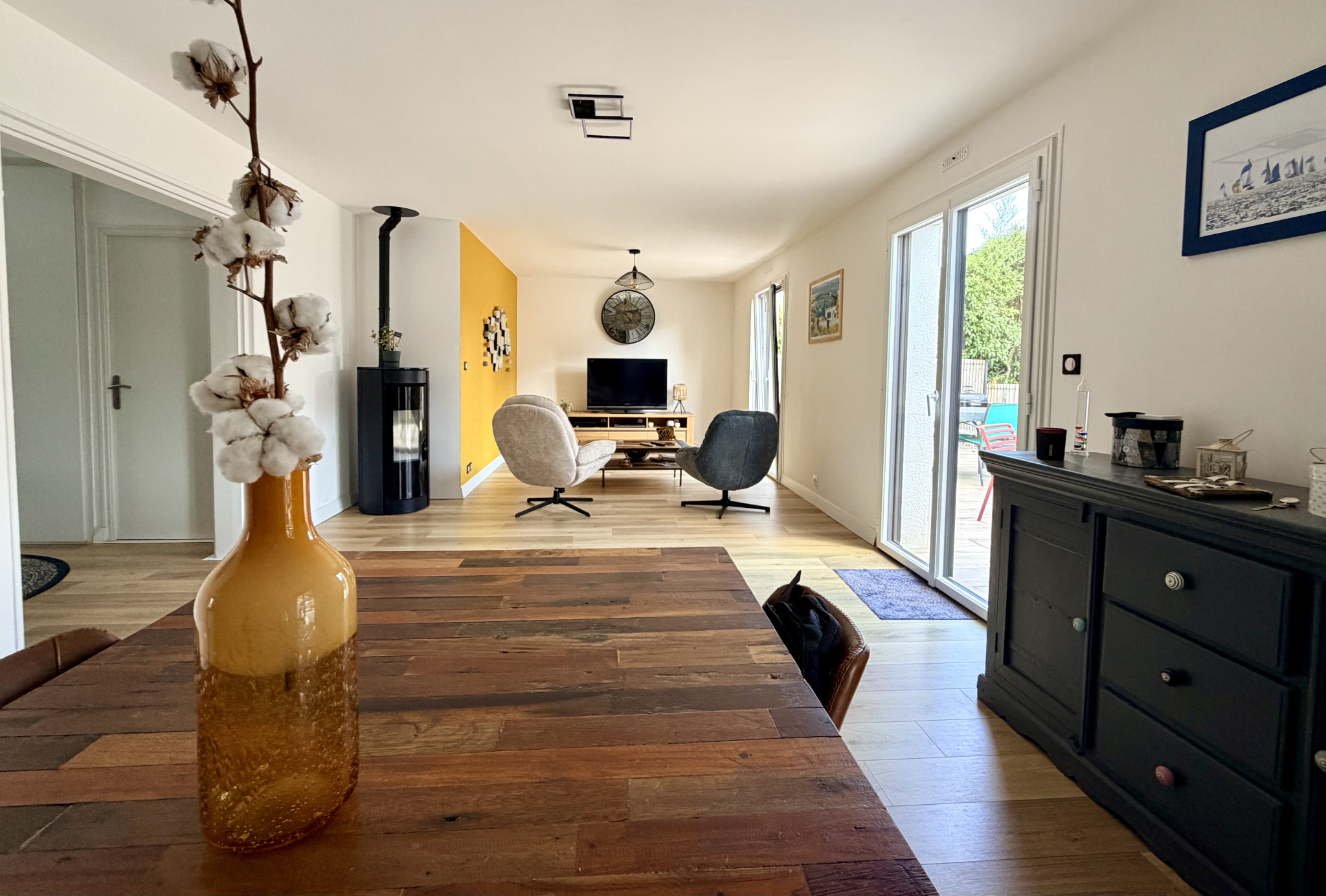 Intérieur d'une maison contemporaine à Vannes avec un salon lumineux et une table en bois.