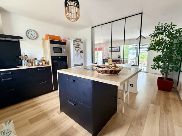 Cuisine moderne avec îlot central et espace dinatoire dans une maison contemporaine à Vannes.