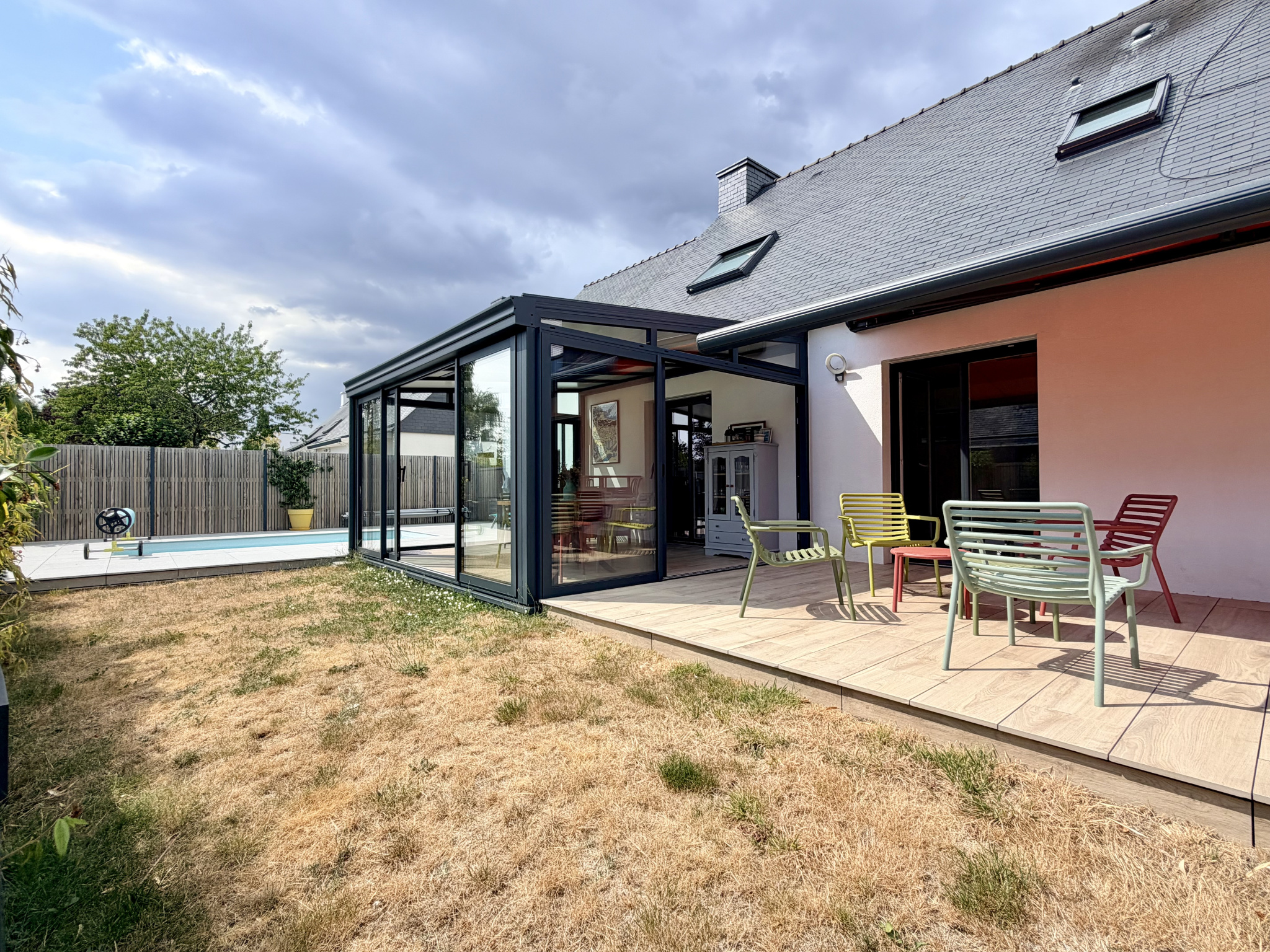 Maison contemporaine avec véranda et piscine à Vannes, vue depuis le jardin.