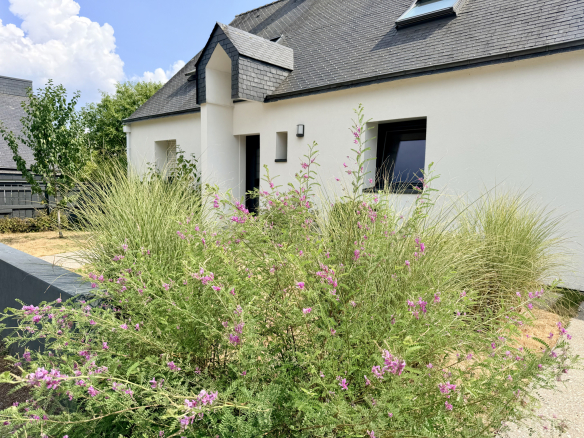 Maison contemporaine avec jardin fleuri à Vannes, entrée moderne et toiture en ardoise.