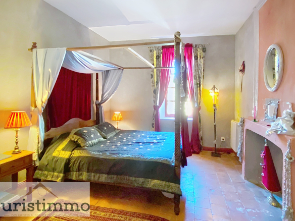 Room in a private mansion with a four-poster bed and elegant decor.
