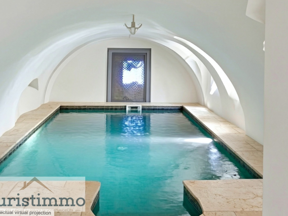 Indoor swimming pool of a private mansion with a vaulted ceiling.