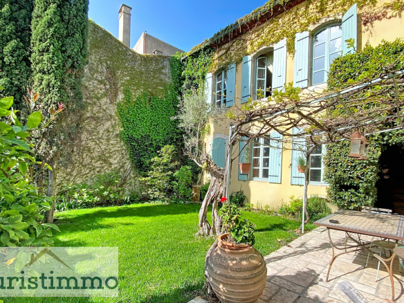 Hanging garden of a private mansion in Saint-Paul-Trois-Châteaux, with greenery and garden furniture.