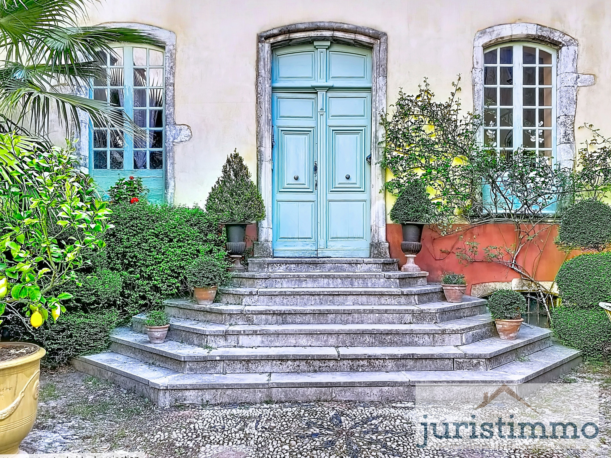 Entrance to a private mansion in the Drôme Provençale region Main entrance of a private mansion with stone stairs and decorative plants in Saint-Paul-Trois-Châteaux.