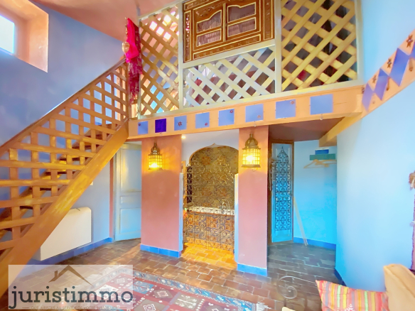 Interior of a private mansion with a wooden staircase and colorful walls.