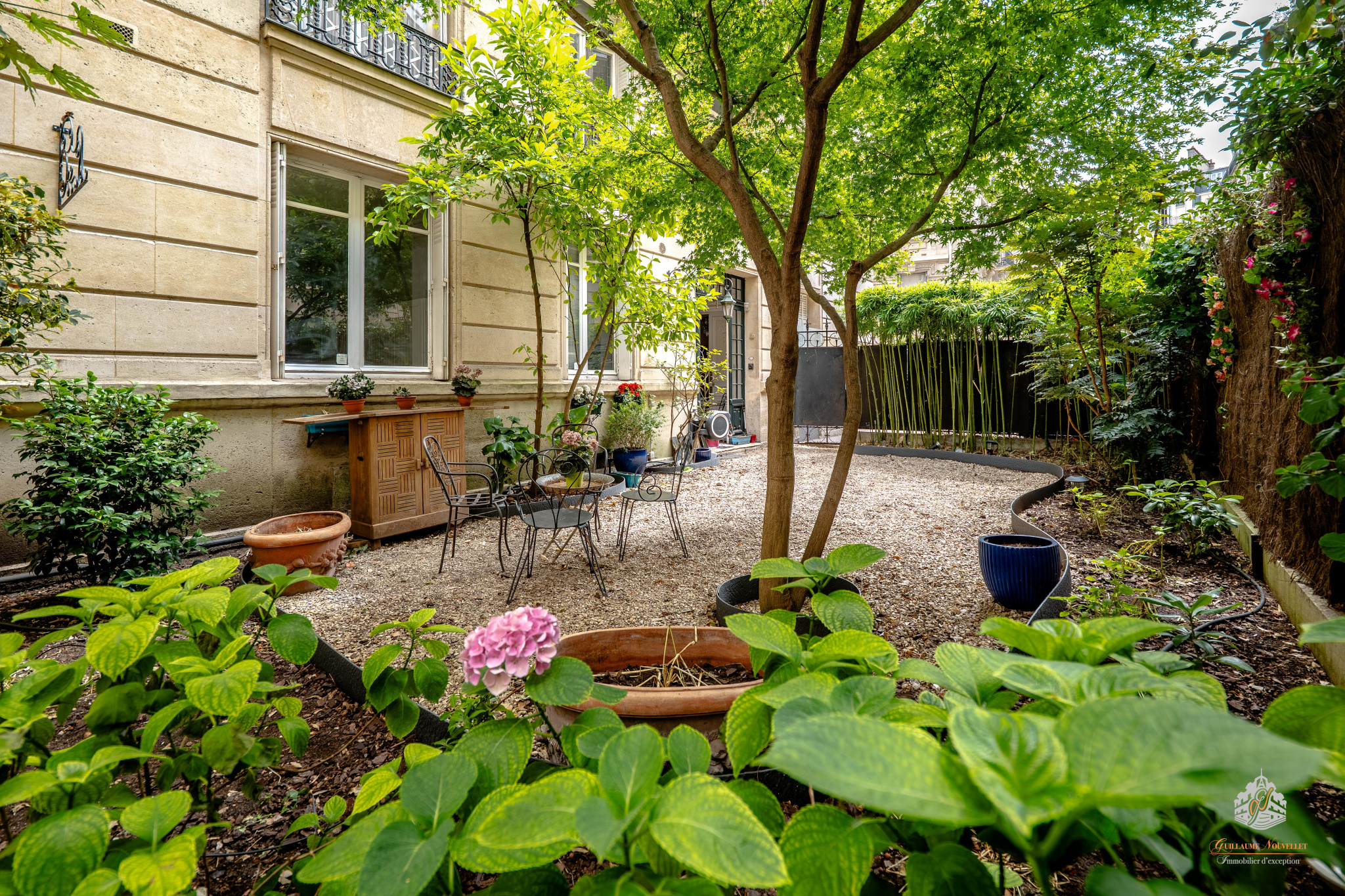 Elegant garden-level apartment in the 17th arrondissement of Paris Private garden with trees and garden furniture in a ground-floor apartment in Paris 17th arrondissement.
