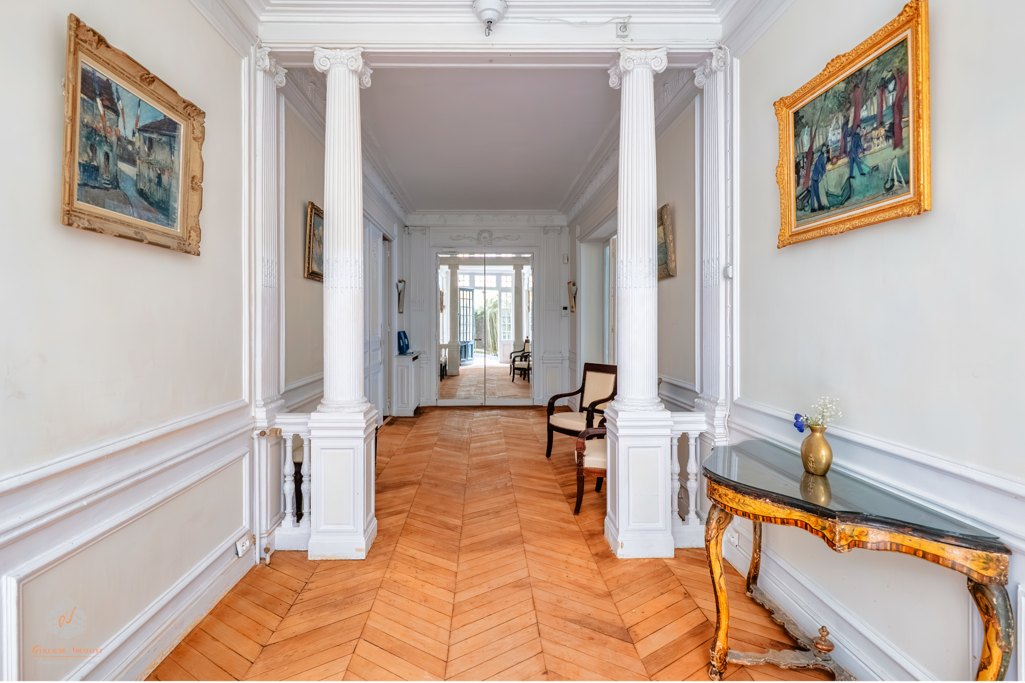Interior of an elegant ground-floor apartment in the 17th arrondissement of Paris Interior of an elegant garden-level apartment with a bright hallway and decorative columns.