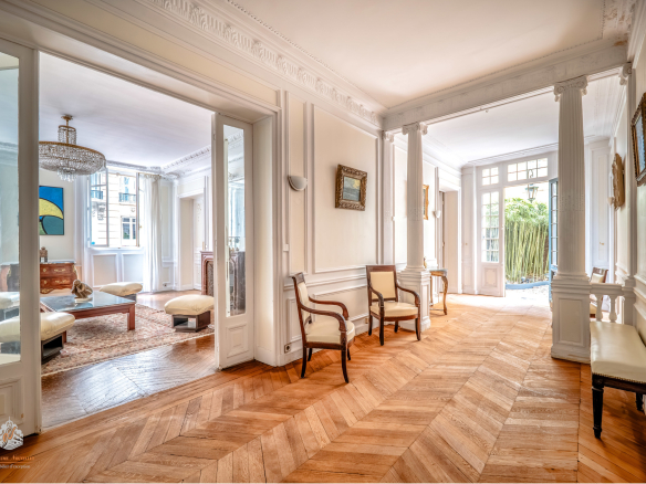 Interior of an elegant ground-floor apartment in Paris' 17th arrondissement with wooden parquet flooring and natural light.